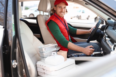 Male courier with orders in car. Food delivery service