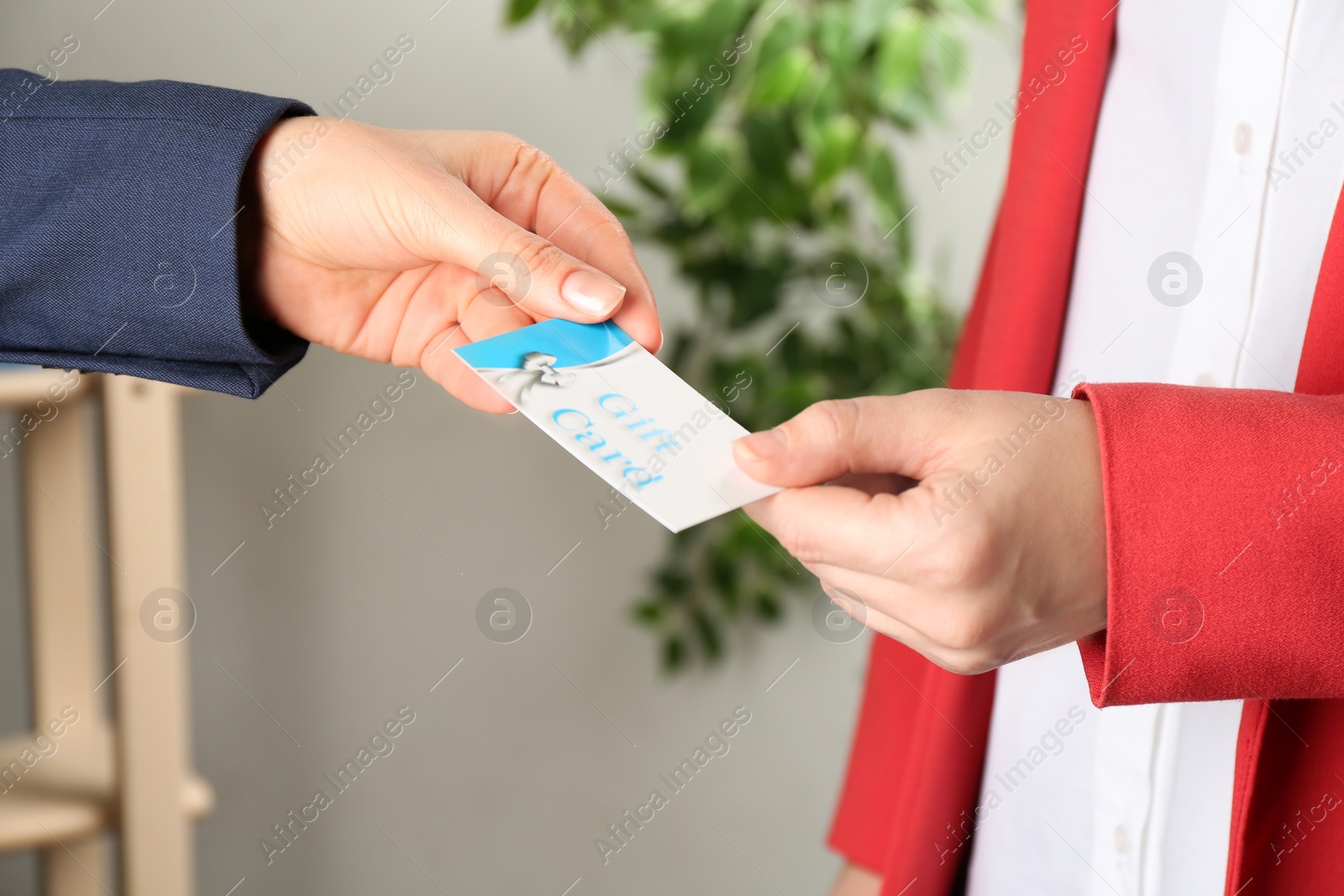 Photo of Women with gift card on blurred background, closeup 