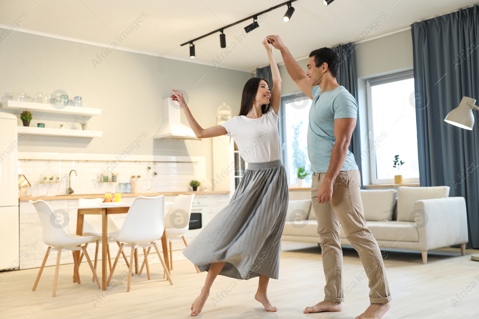 Photo of Lovely young interracial couple dancing at home