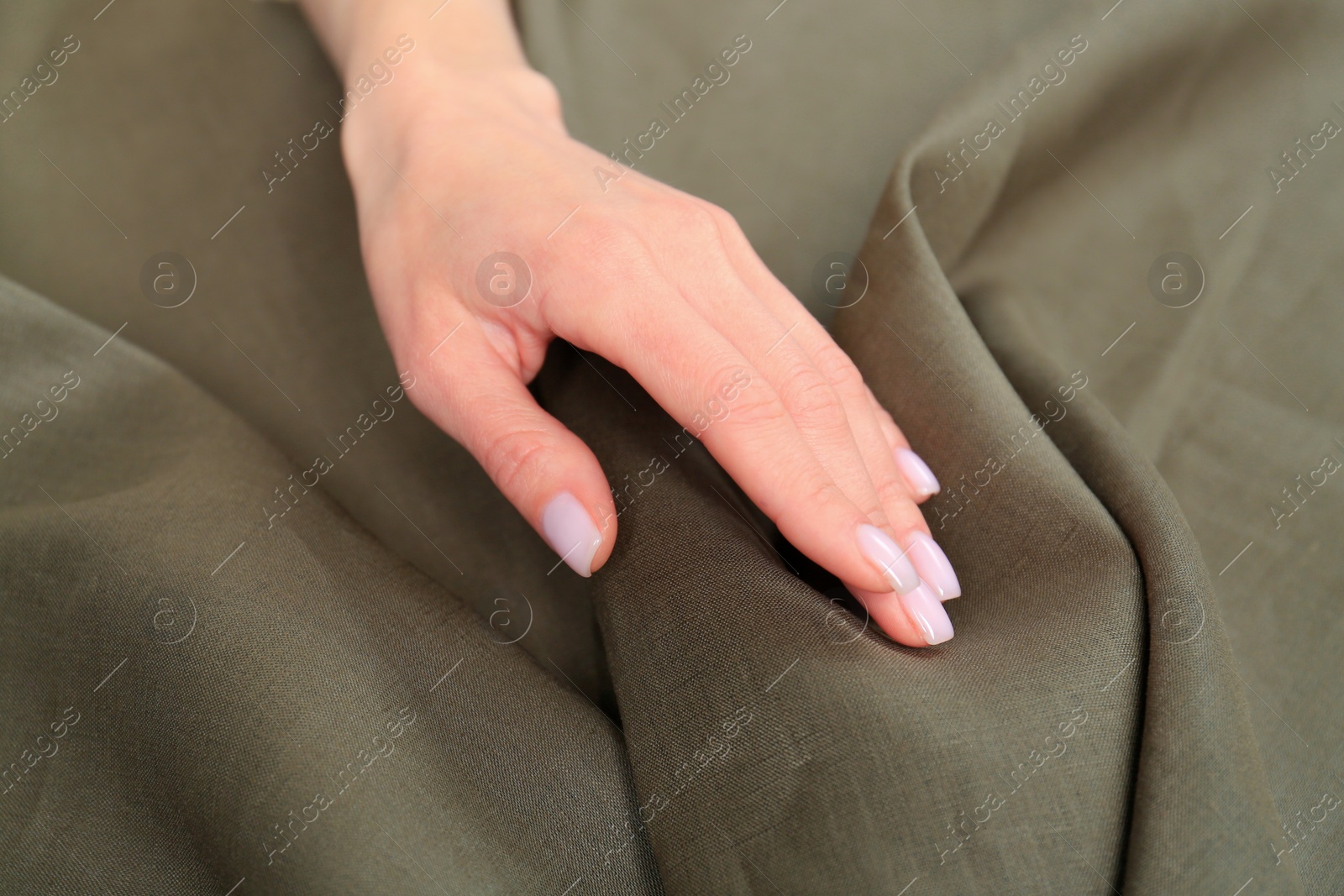 Photo of Woman touching soft olive fabric, closeup view