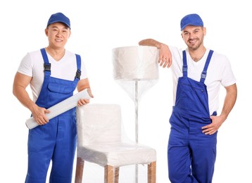 Workers near chair and lamp wrapped in stretch film on white background