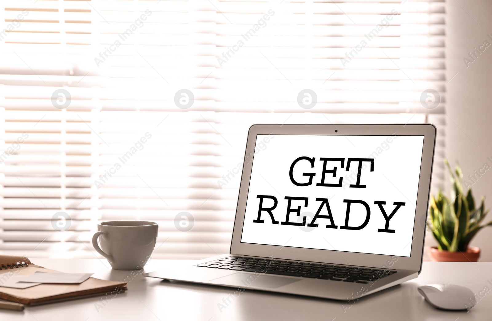 Image of Modern laptop with phrase Get Ready on screen in office