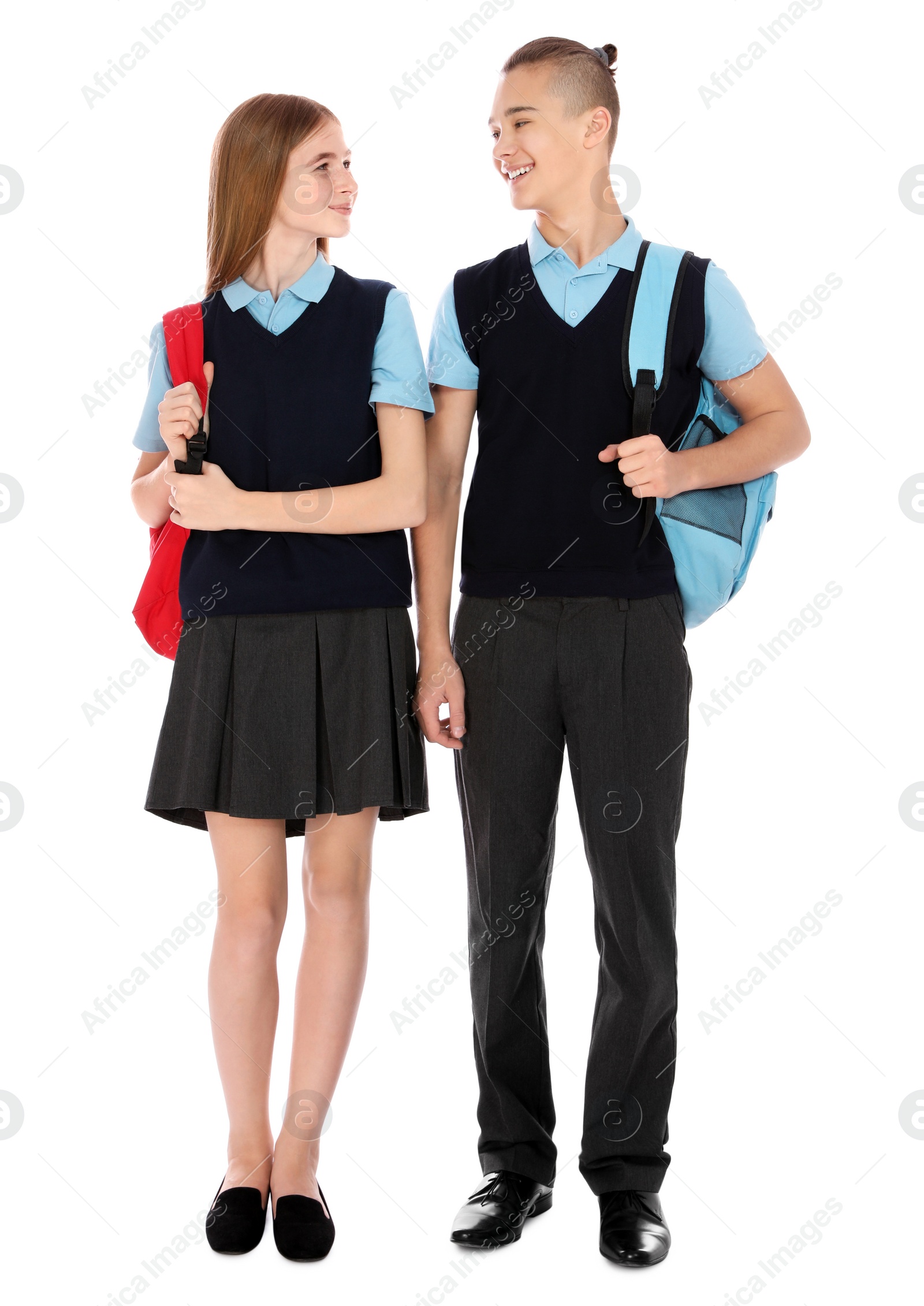 Photo of Full length portrait of teenagers in school uniform with backpacks on white background