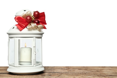 Photo of Decorated Christmas lantern with burning candle on wooden table, space for text