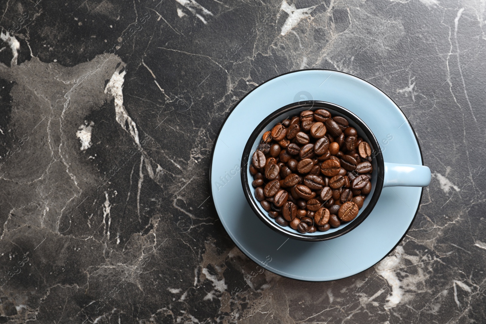 Photo of Cup with roasted coffee beans and space for text on grey background, top view