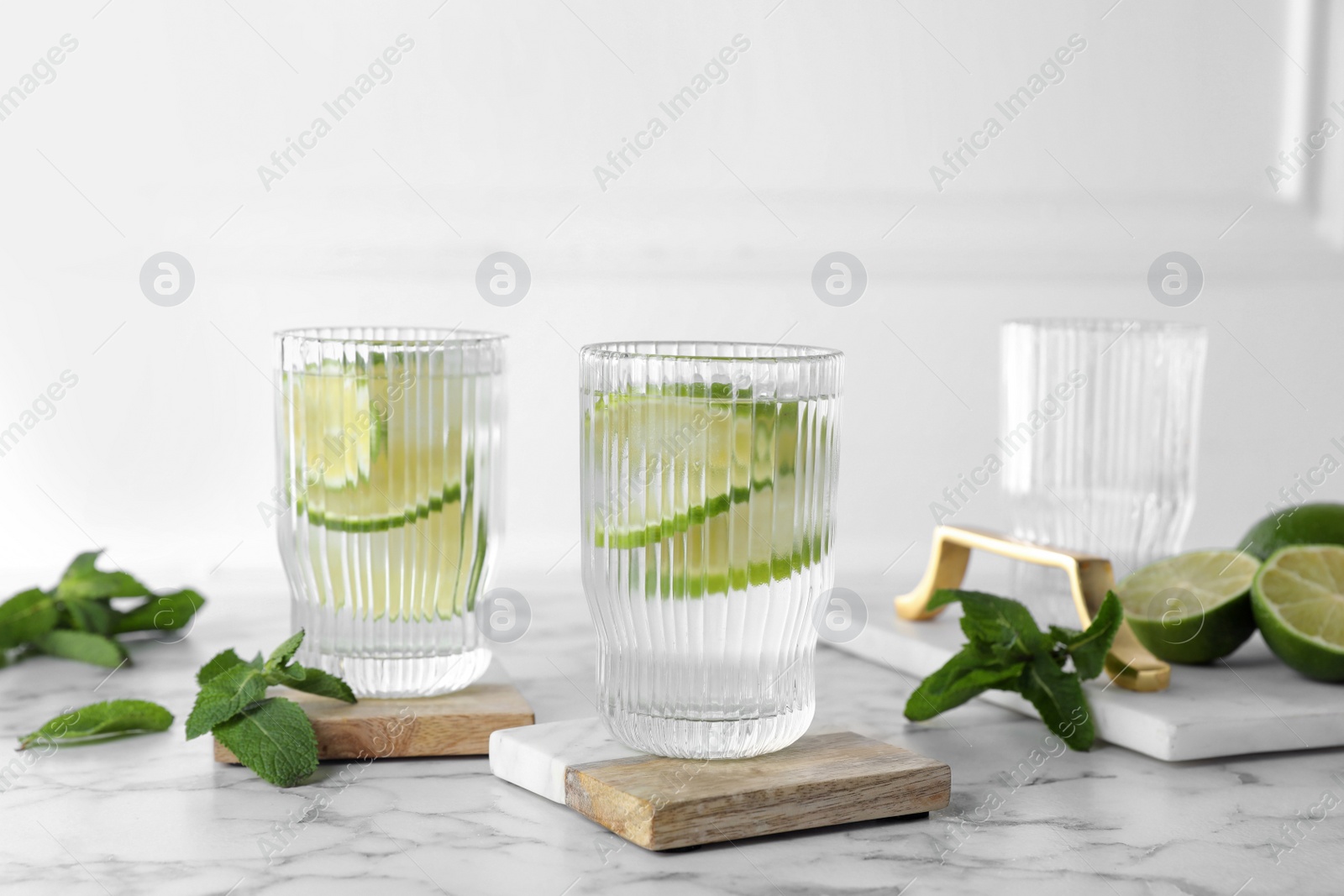 Photo of Glasses of lemonade with stylish cup coasters on marble table