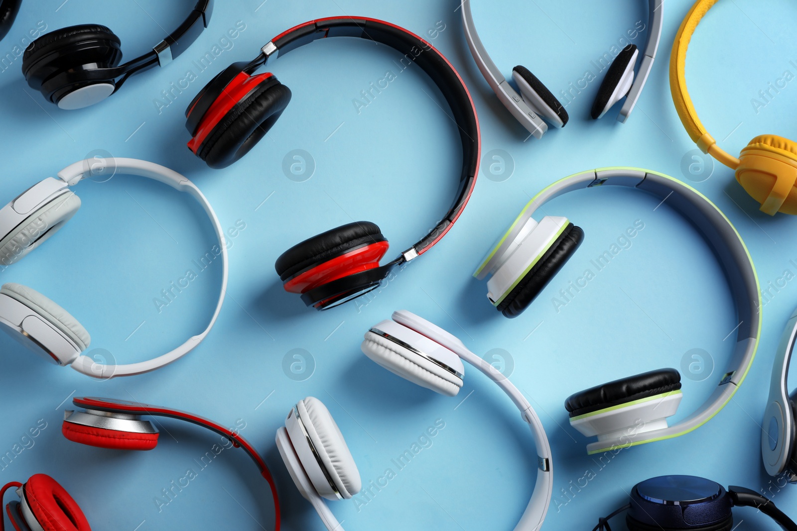 Photo of Many different headphones on color background, top view