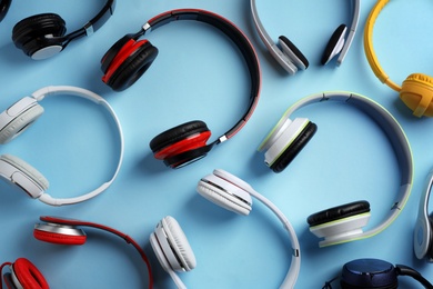 Photo of Many different headphones on color background, top view