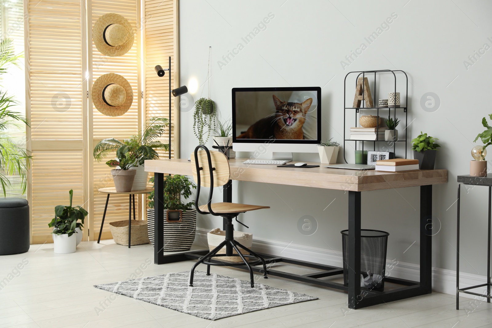 Photo of Comfortable workplace with computer in light room. Interior design