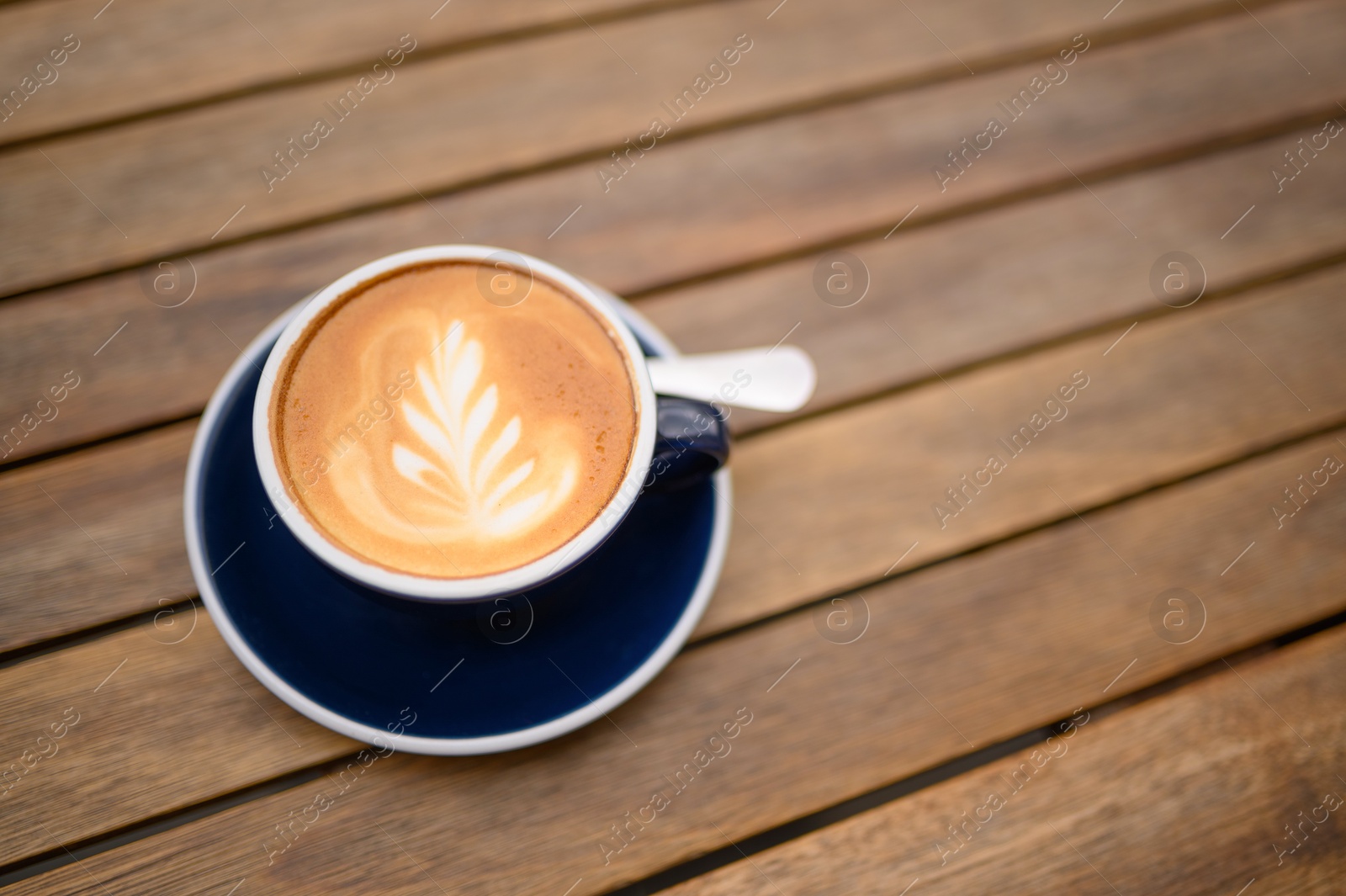 Photo of Cup of aromatic coffee on wooden table, above view. Space for text