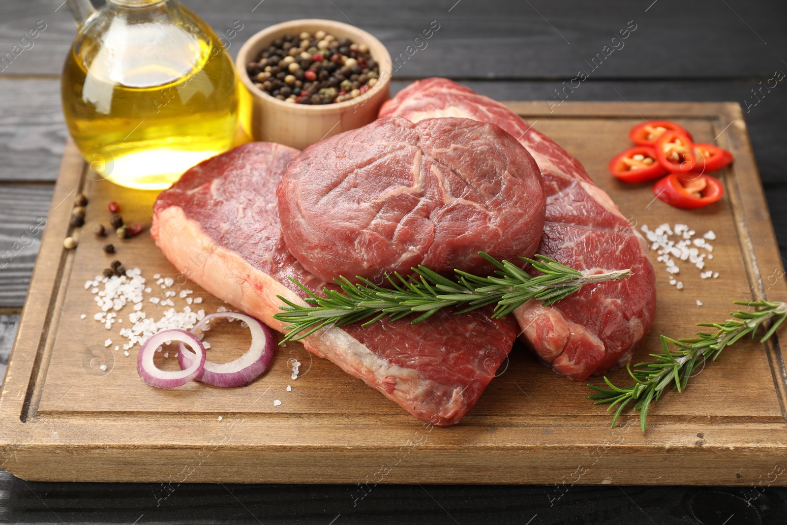 Photo of Pieces of raw beef meat and spices on table, closeup