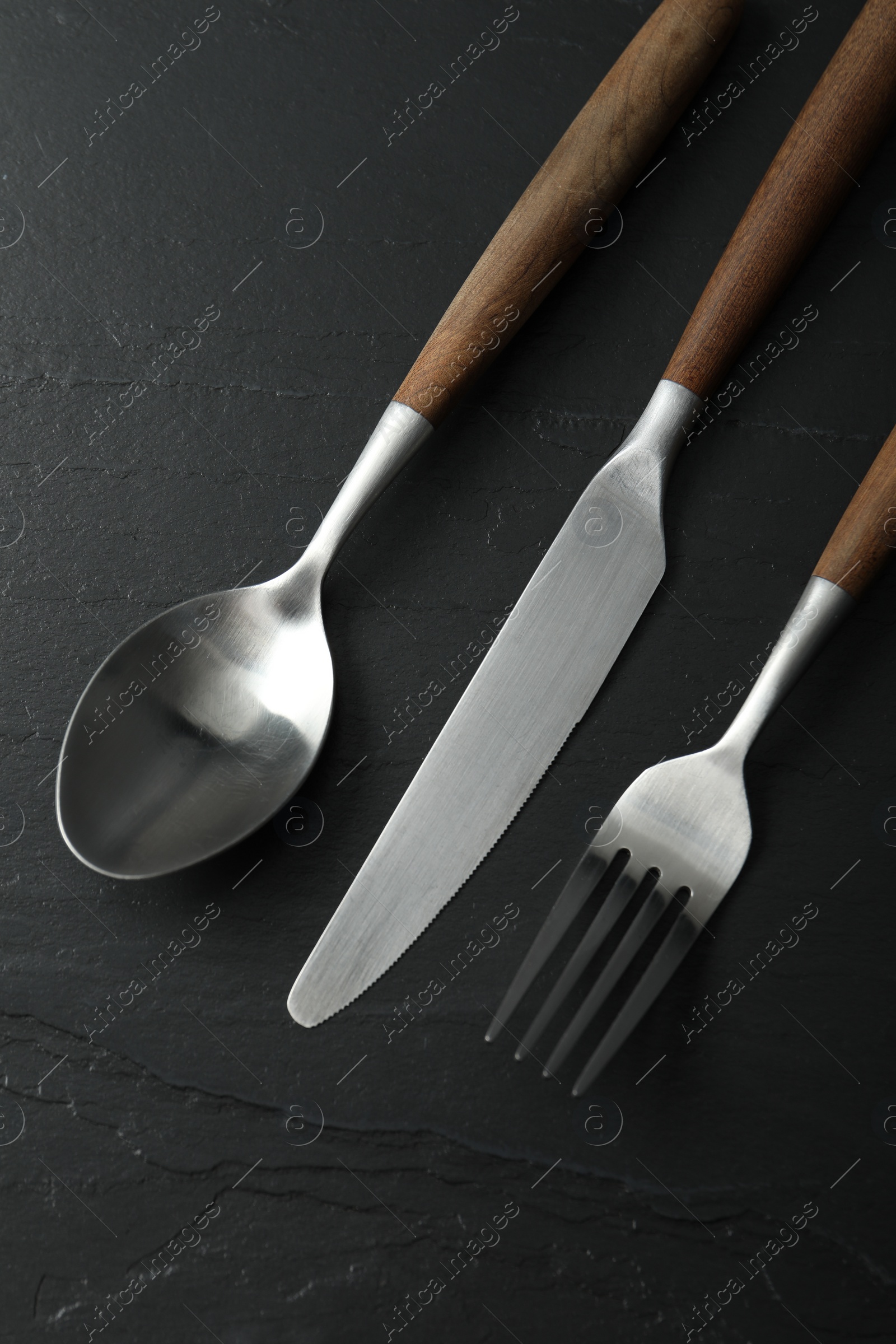 Photo of Stylish cutlery on black table, flat lay