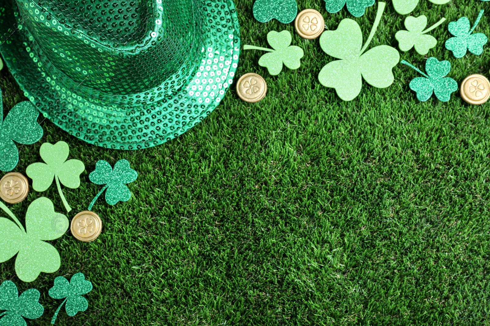 Photo of Flat lay composition with clover leaves on green grass, space for text. St. Patrick's Day celebration