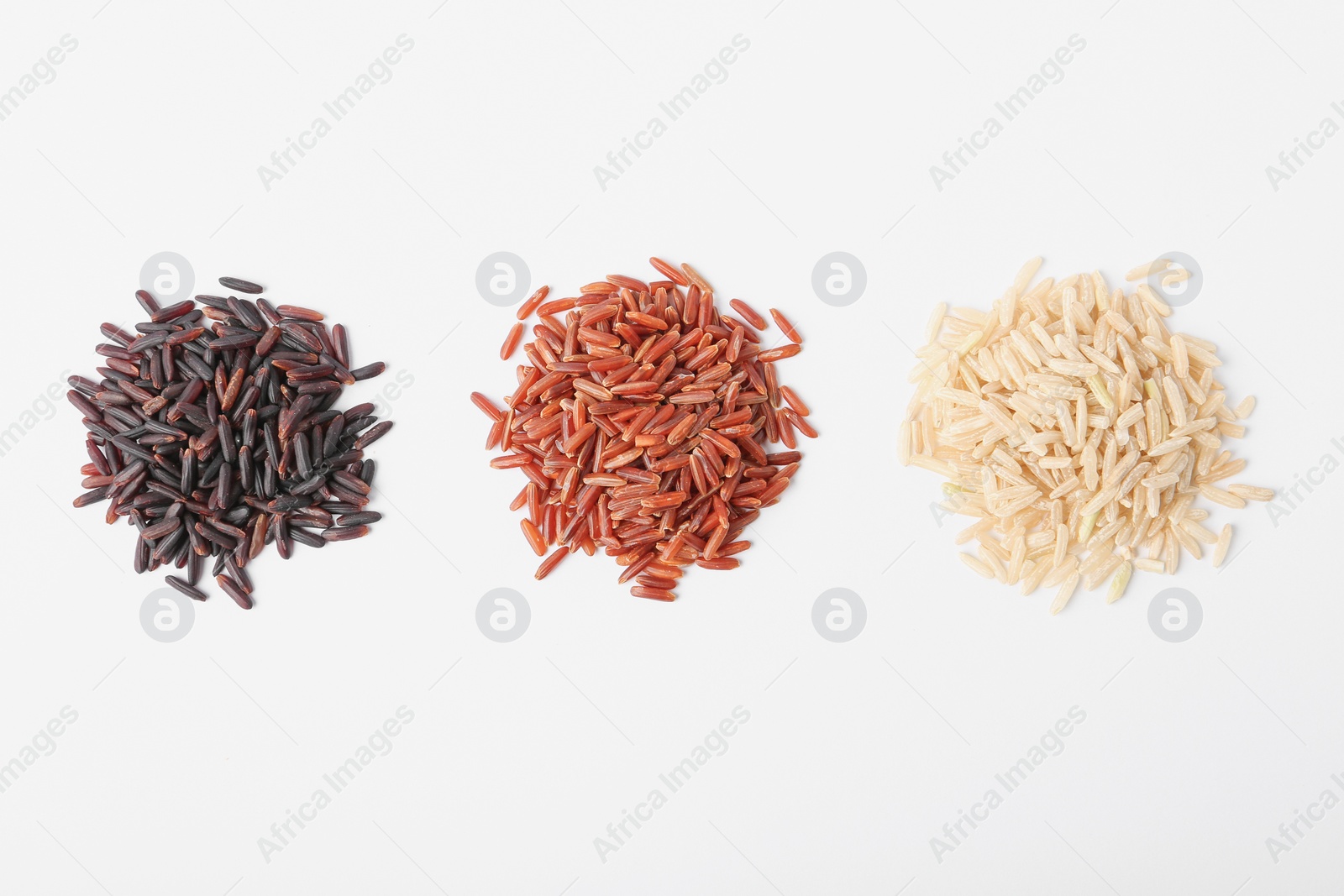 Photo of Different types of uncooked rice on white background, top view