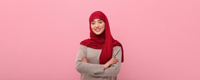 Portrait of Muslim woman in hijab on pink background. Banner design