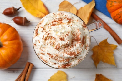 Photo of Delicious pumpkin latte on white table, top view