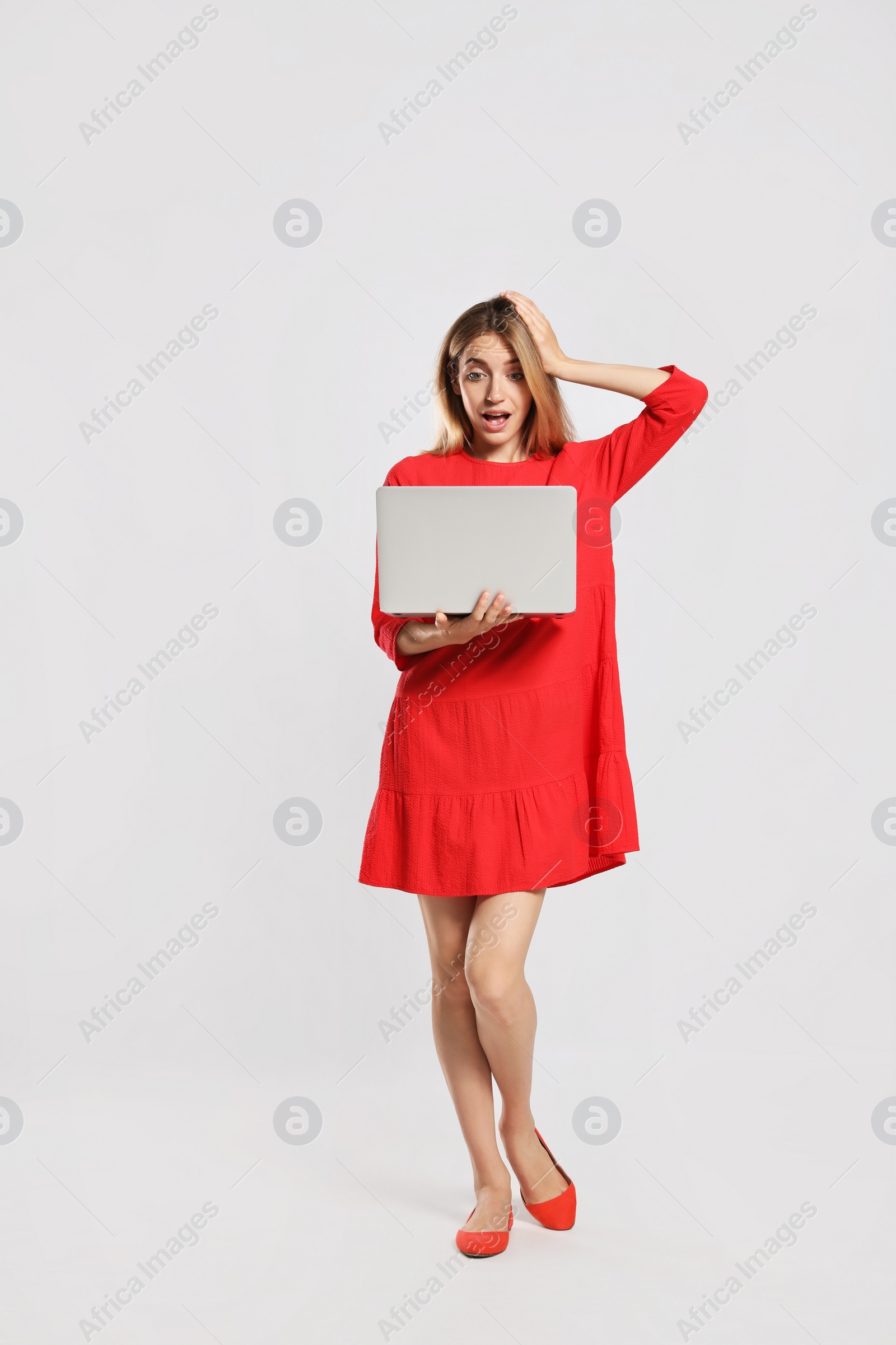 Photo of Full length portrait of emotional woman with modern laptop on light grey background