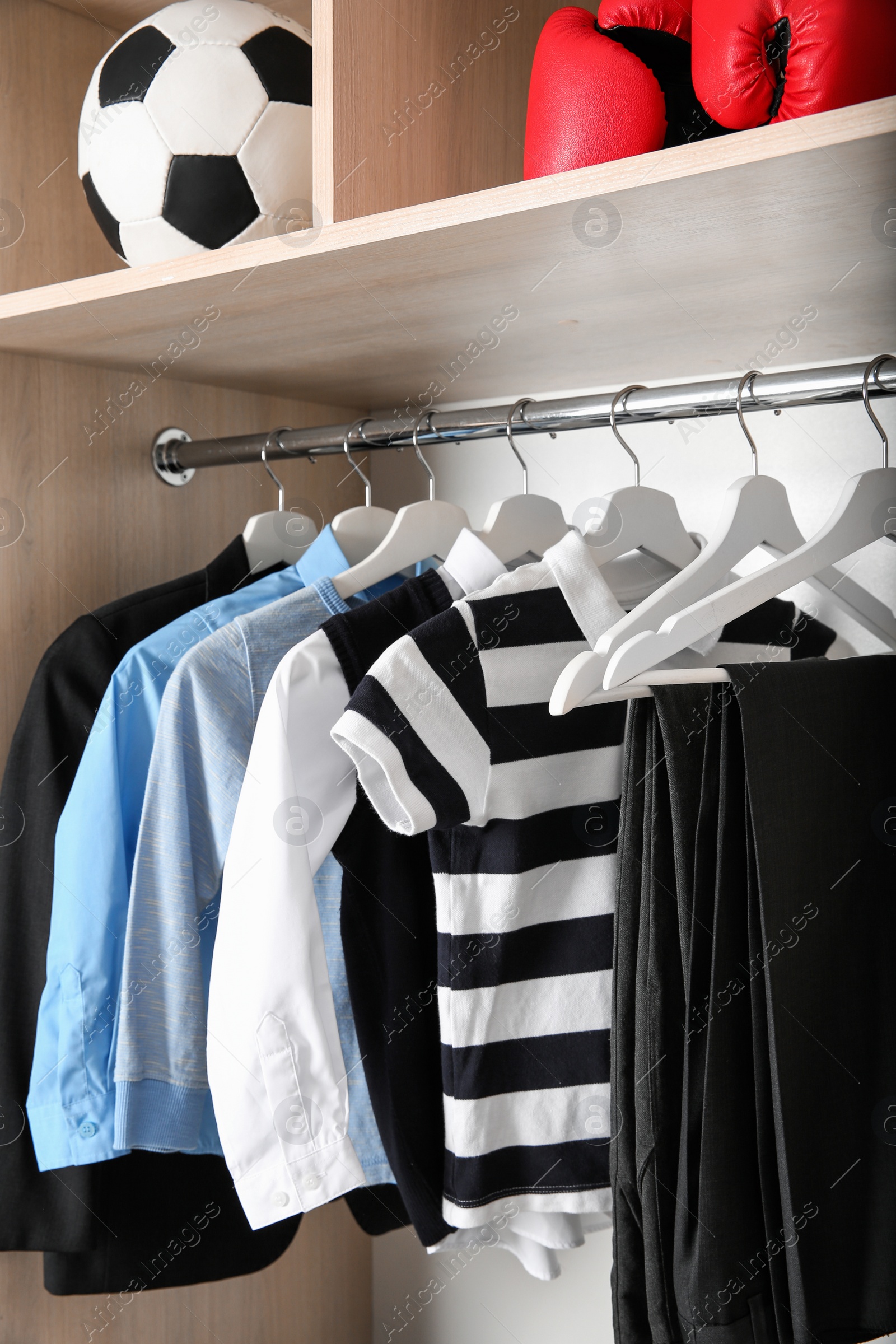 Photo of Wardrobe with stylish boy's clothes hanging on rack