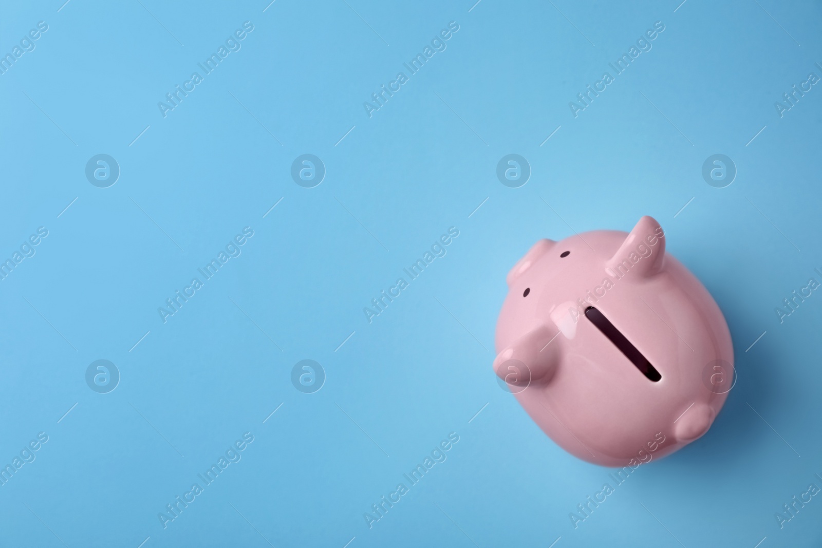 Photo of Pink piggy bank on color background, top view