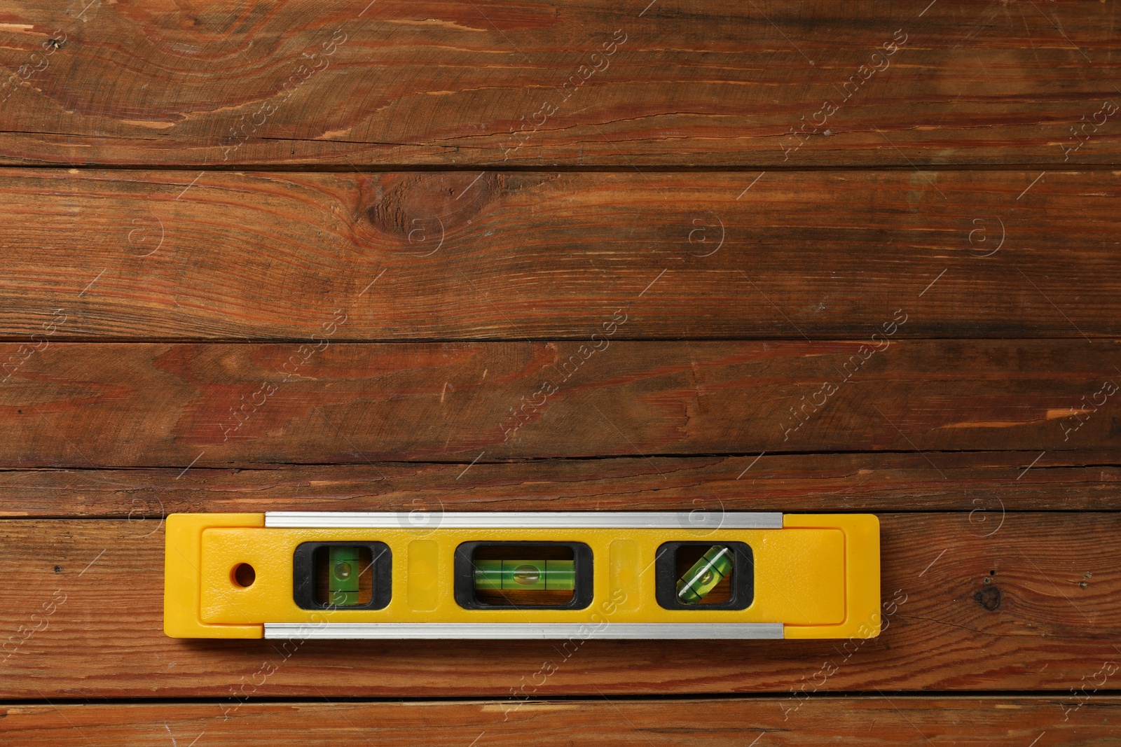 Photo of Building level on wooden table, top view. Space for text