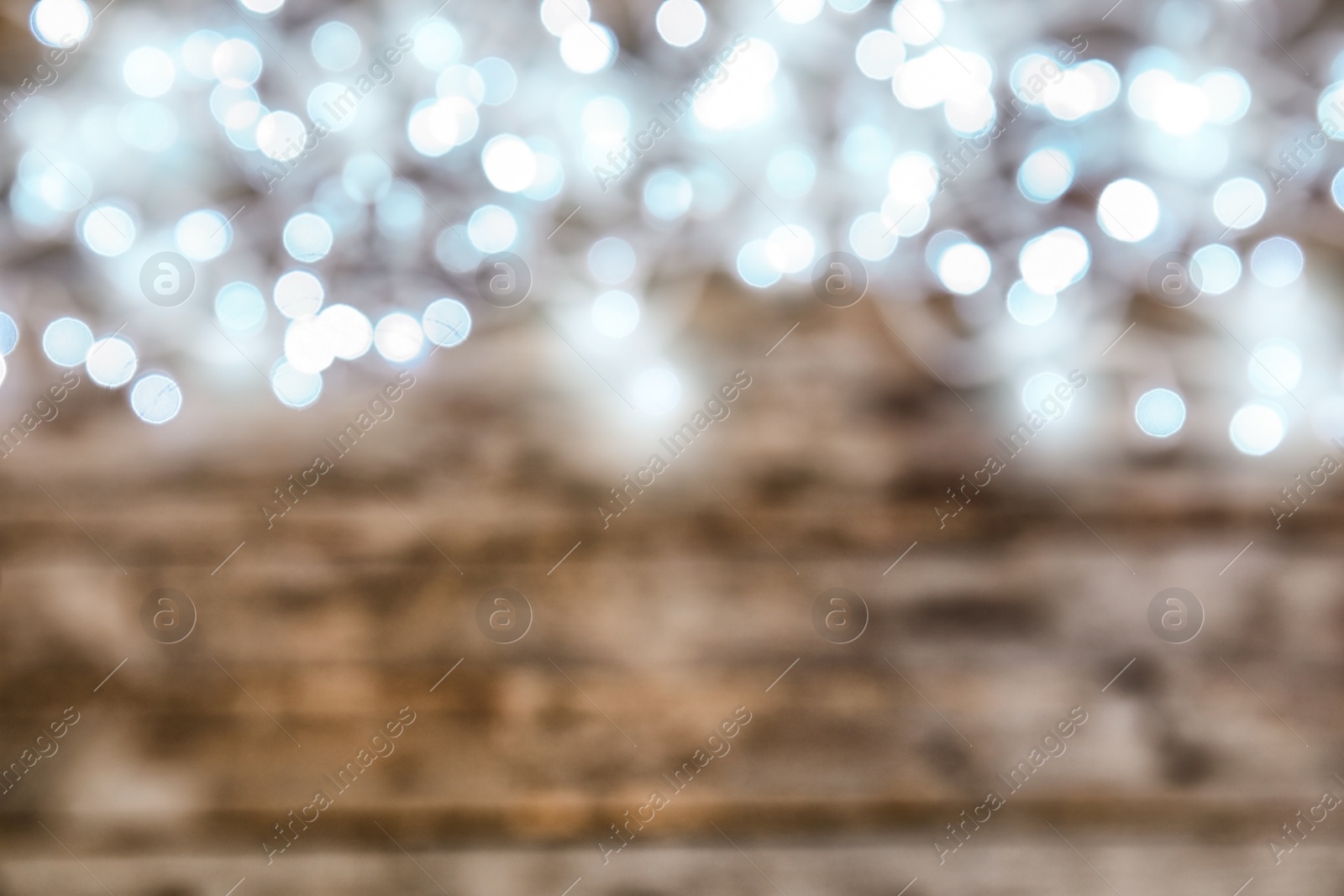 Photo of Blurred view of glowing Christmas lights on color background, top view