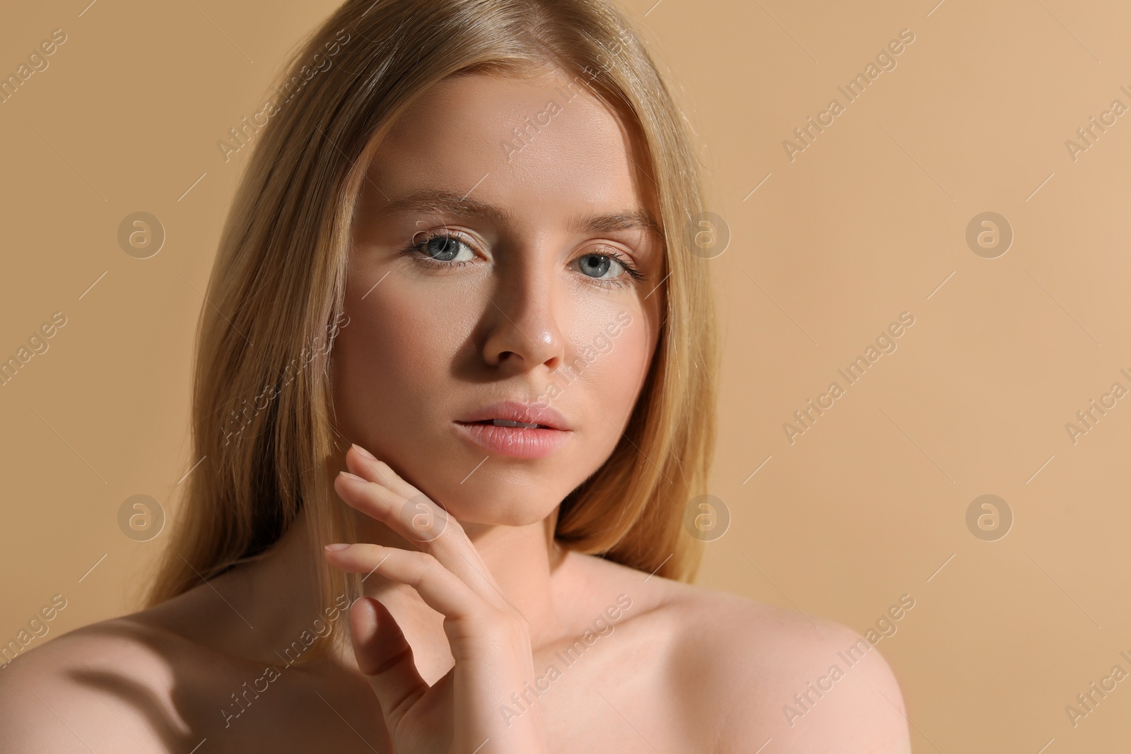 Photo of Beautiful young woman posing on beige background