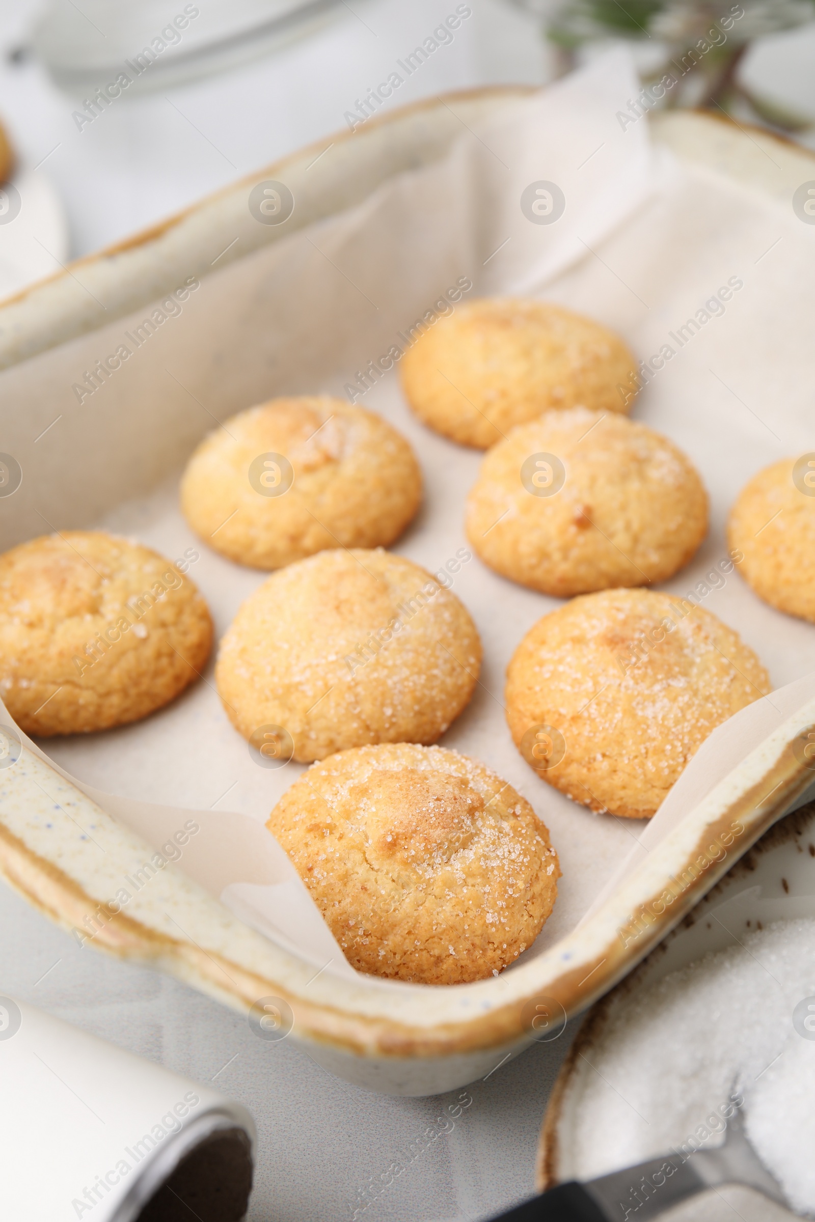 Photo of Tasty sweet sugar cookies in baking dish on white tiled table, closeup