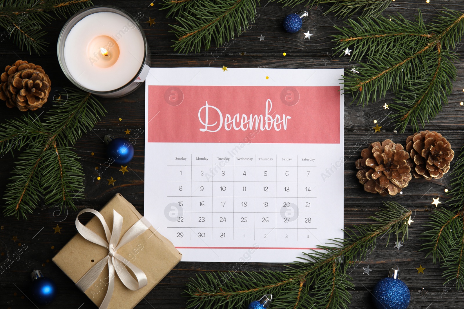 Photo of Flat lay composition with paper calendar on black wooden table