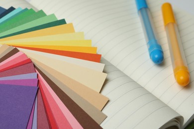 Photo of Color palette and pens on notebook, closeup