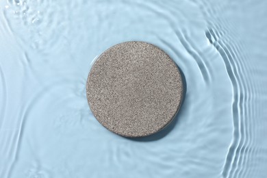 Presentation for product. Stone podium in water on light blue background, top view