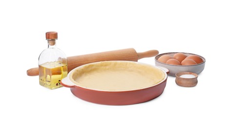 Photo of Pie tin with fresh dough, rolling pin and ingredients isolated on white. Making quiche