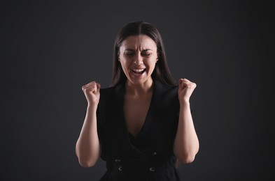 Photo of Portrait of emotional young woman on black background. Personality concept