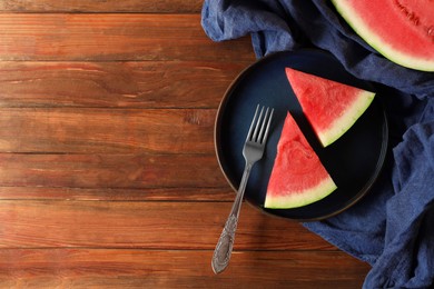 Photo of Sliced fresh juicy watermelon served on wooden table, flat lay. Space for text