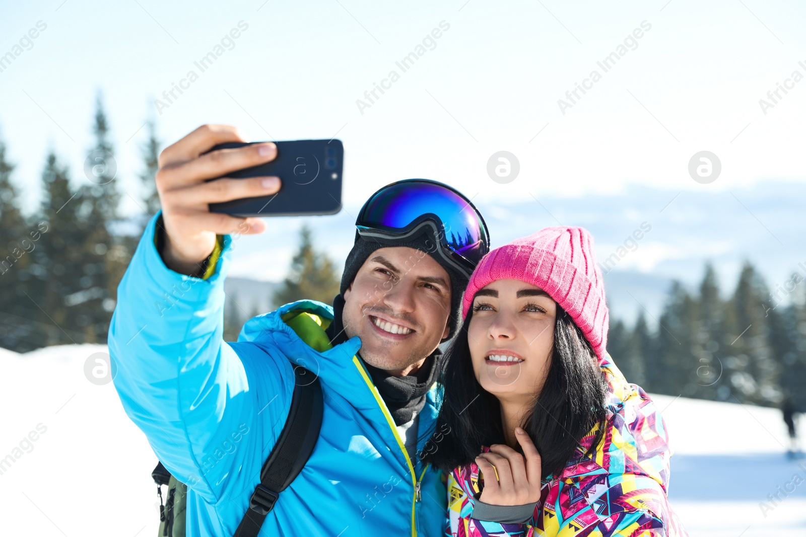 Photo of Happy couple taking selfie in mountains. Winter vacation