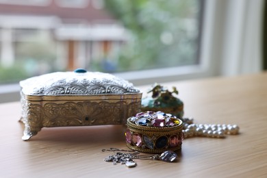 Photo of Stylish jewelry boxes and different accessories on wooden table indoors