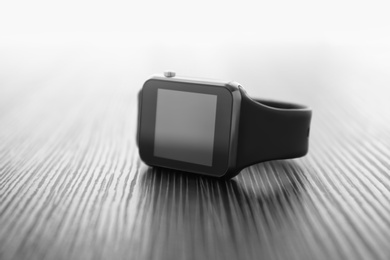 Photo of Modern stylish smart watch on black table, closeup