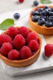 Photo of Tartlet with fresh raspberries on table, closeup. Delicious dessert