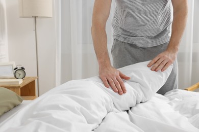 Man changing bed linens at home, closeup. Space for text