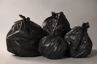 Photo of Trash bags full of garbage on grey background