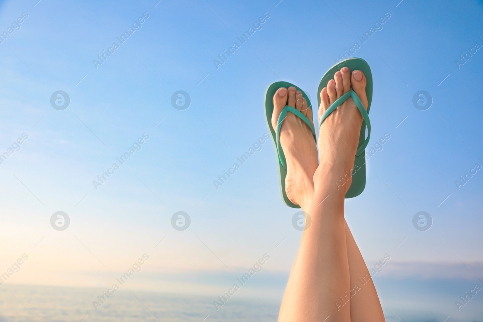 Photo of Woman in stylish flip flops against sky, closeup. Space for text