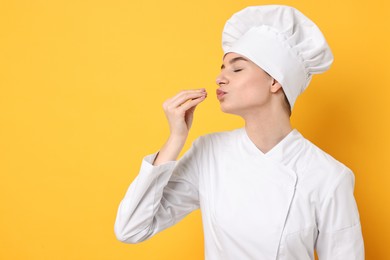 Photo of Professional chef showing perfect sign on yellow background. Space for text