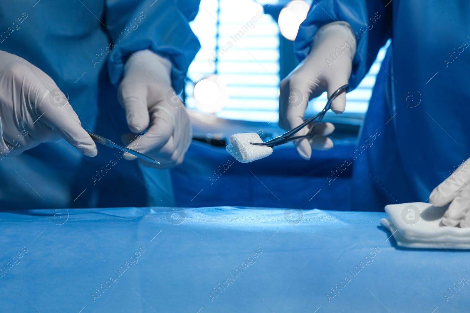 Photo of Professional surgeons with instruments performing operation in clinic, closeup