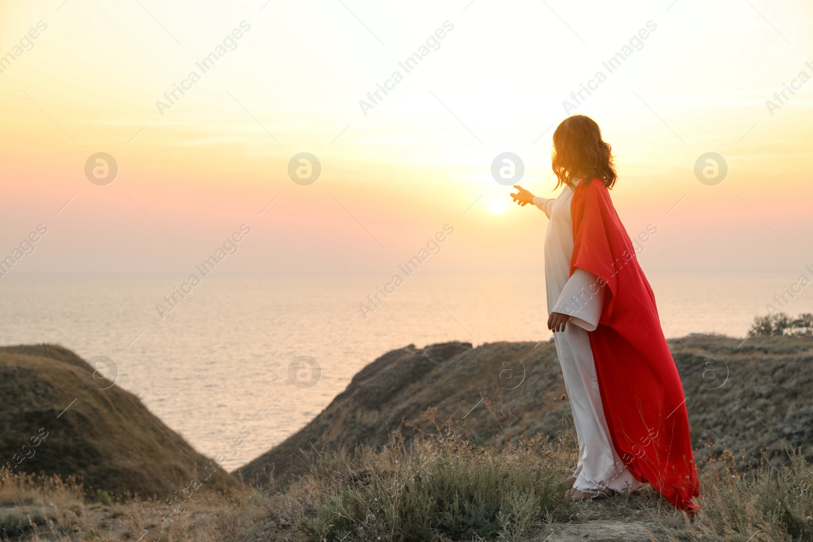 Photo of Jesus Christ on hills at sunset. Space for text