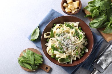 Photo of Delicious pasta with green peas and ingredients on grey table, flat lay. Space for text