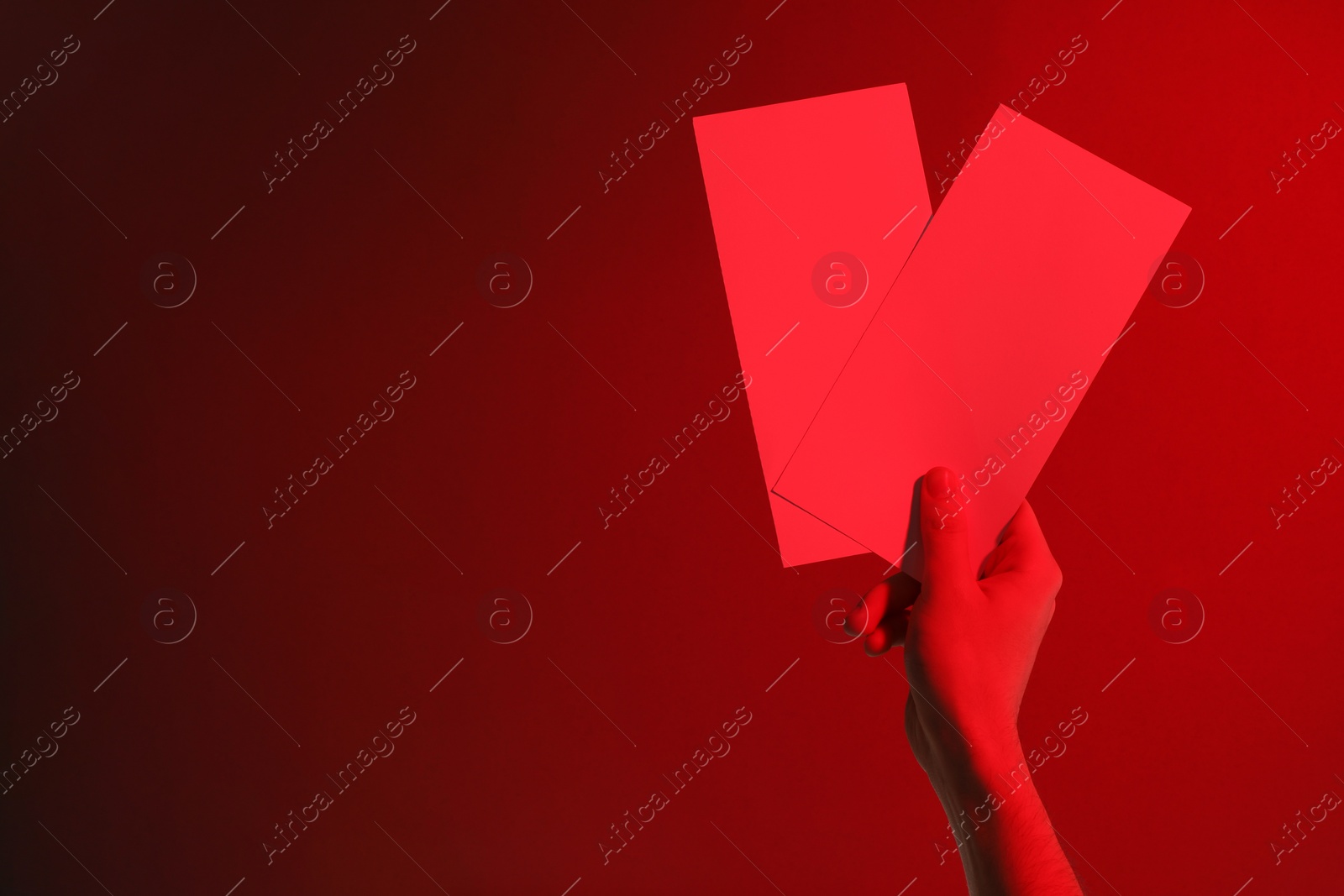 Photo of Man holding flyers on red background, closeup and space for text. Color tone effect