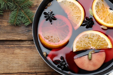 Delicious mulled wine on wooden table, top view