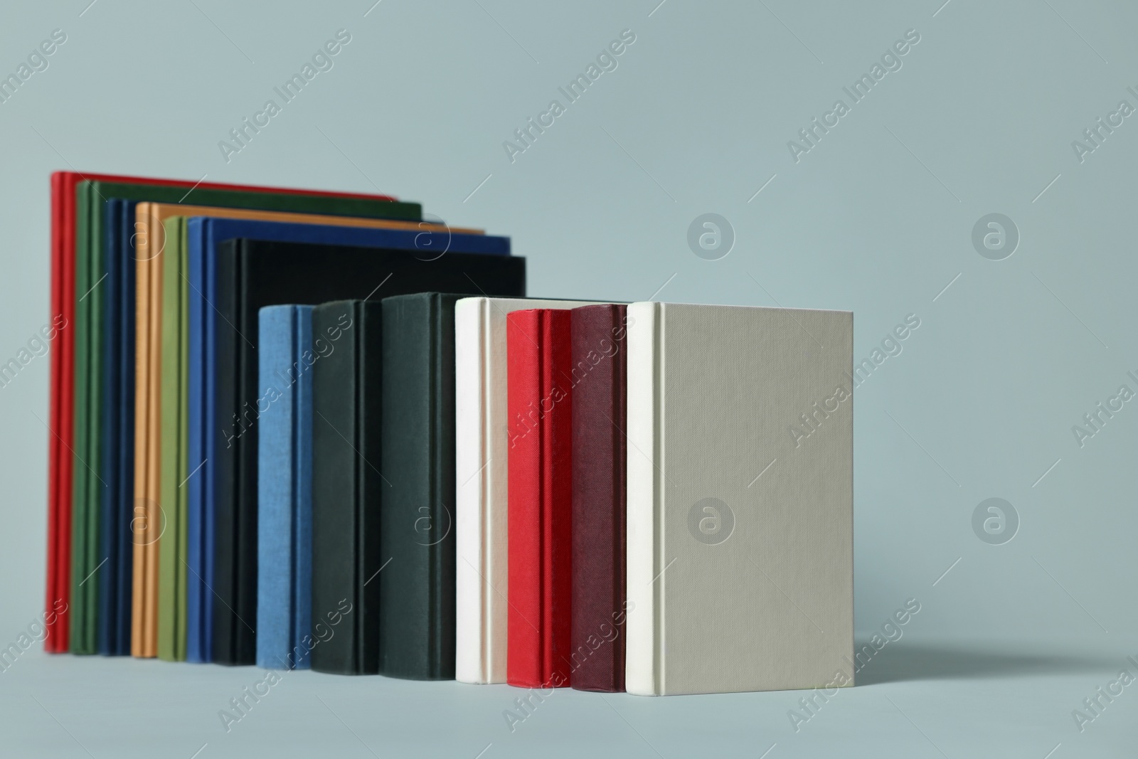 Photo of Many different hardcover books on light grey background