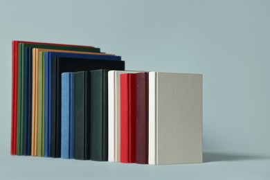Photo of Many different hardcover books on light grey background
