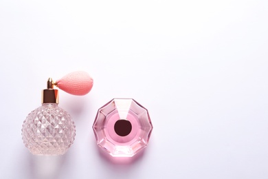 Composition with bottles of perfume on white background, top view