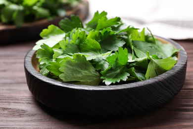 Photo of Fresh green parsley on wooden table, closeup